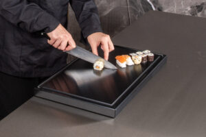 Schwarzes Polyhygien Schneidbrett mit Sushi